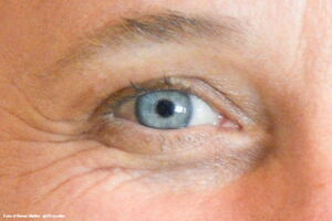 Das Auge einer Frau schaut auf den Betrachter.