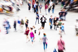 Ein Mann steht ohnmächtig auf einem großen Platz. Alle Menschen um ihn herum bewegen sich ganz schnell. Er hat Angst vor großen Plätzen und möchte diese gerne loswerden. Mit Hypnose ist dies möglich.