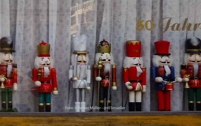 8 Nussknacker aus dem Erzgebirge stehen in einem Schaufenster.