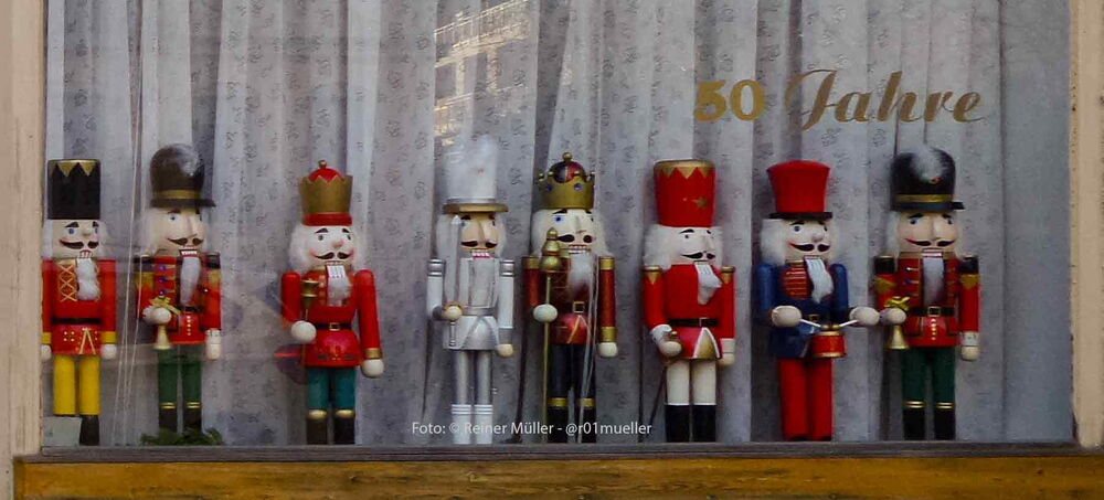 Eine Gruppe von 8 Nussknackern steht in einem Schaufenster. Unter ihnen sind Könige, Soldaten, Offiziere und Förster.