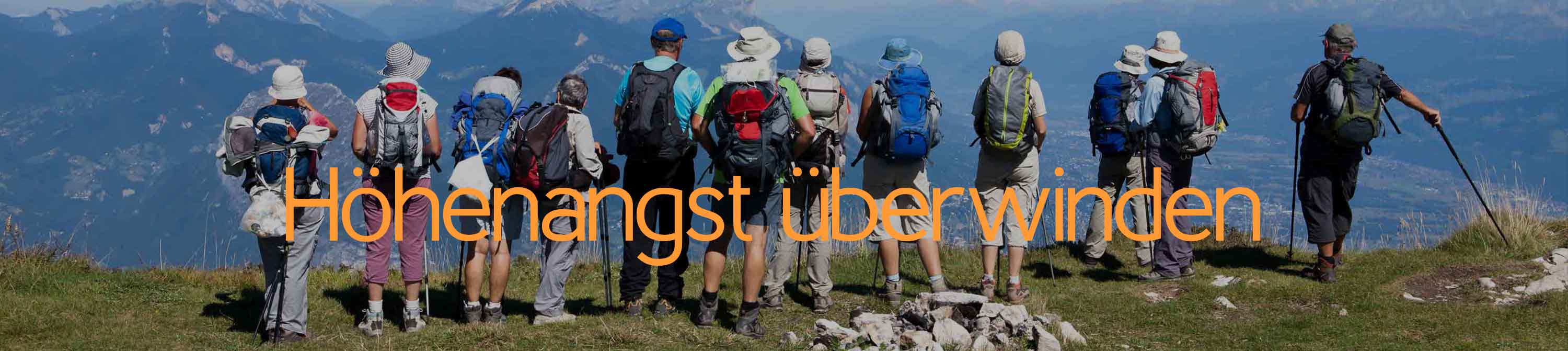 Eine Höhenangst überwinden. Menschengruppe von Wanderern mit Rucksäcken steht an einem Abhang und schaut in die Tiefe, in das Tal. Höhenangst kann überwunden werden.