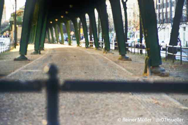 Eine U-Bahn-Unterführung. Links und rechts davon ist Straße. Im Vordergrund steht ein Geländer im Weg.
